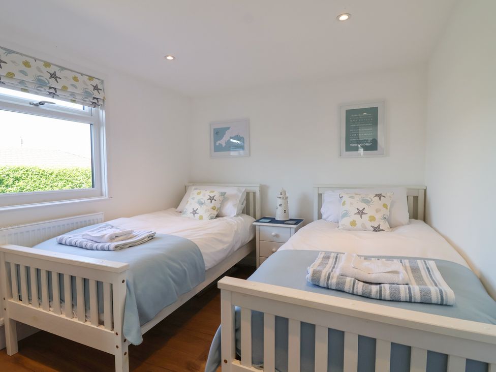 A bedroom with two beds and a nightstand at Stella Maris in Torpoint