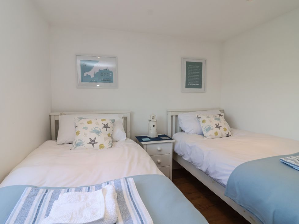A bedroom with two single beds and a nightstand at Stella Maris in Torpoint