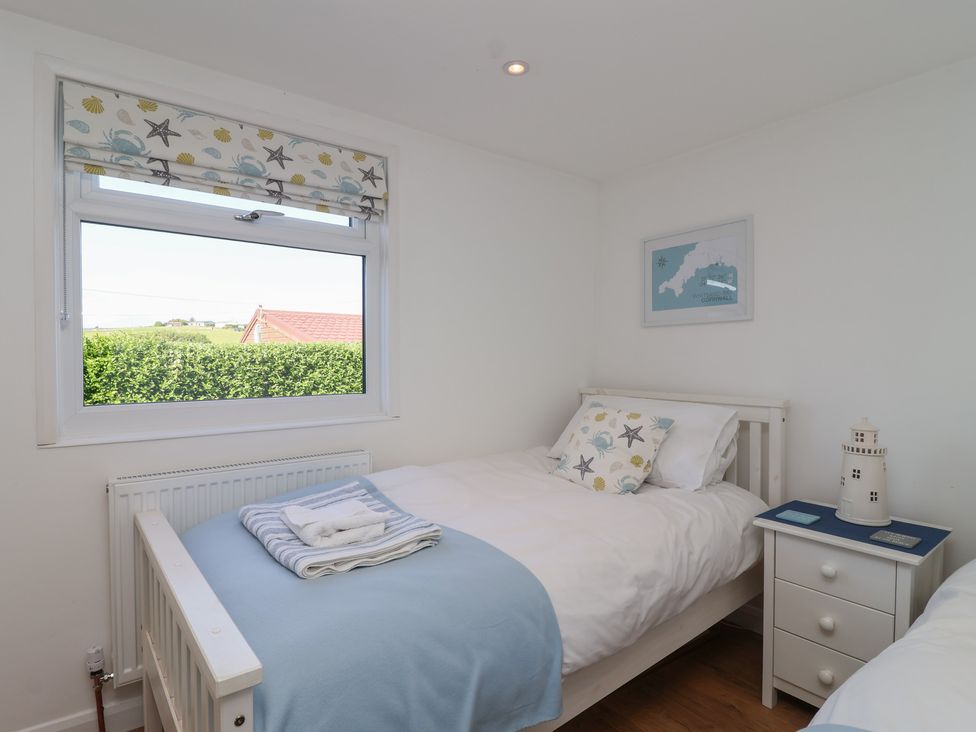 A bedroom with two beds and a window at Stella Maris in Torpoint