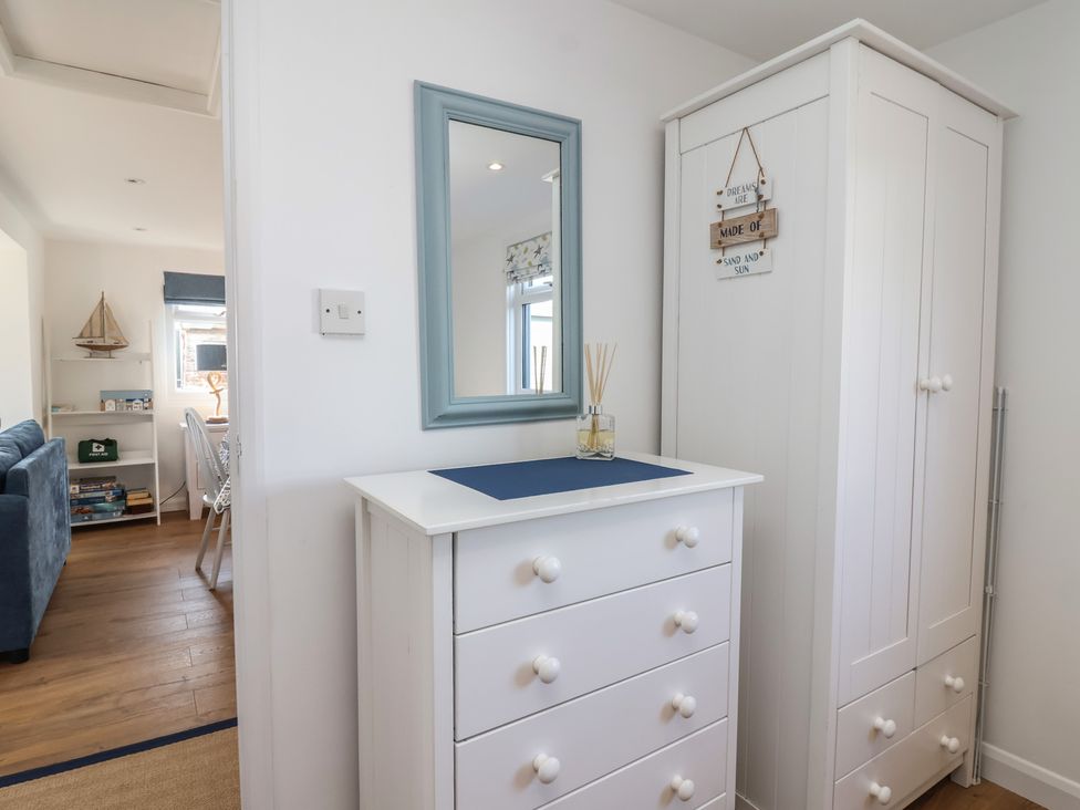 A hallway with a chest of drawers and mirror at Stella Maris in Torpoint