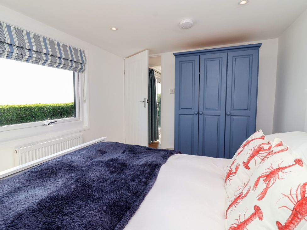 A bedroom with a bed and blue wardrobe at Stella Maris in Torpoint