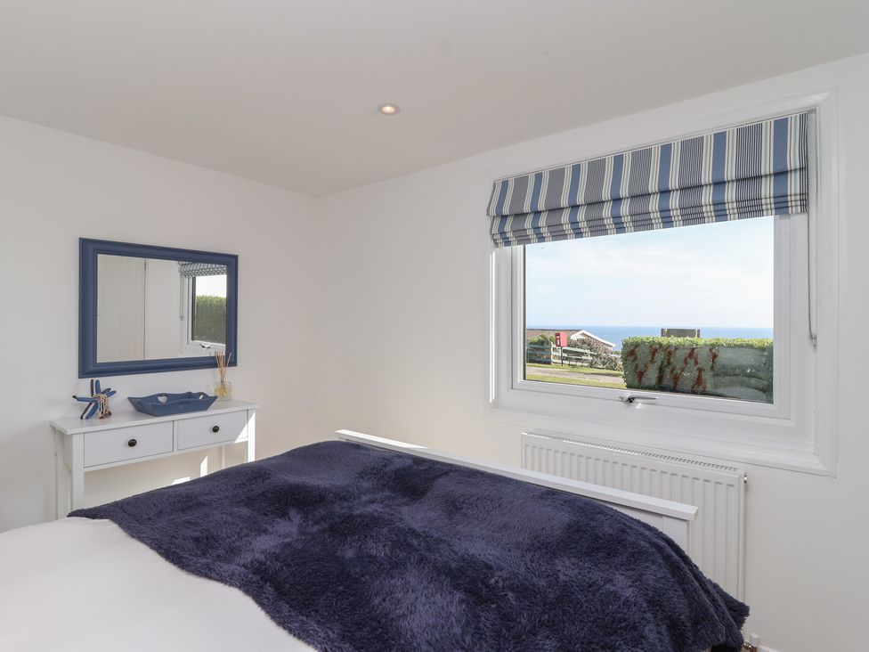 A bedroom with a bed and window view at Stella Maris in Torpoint