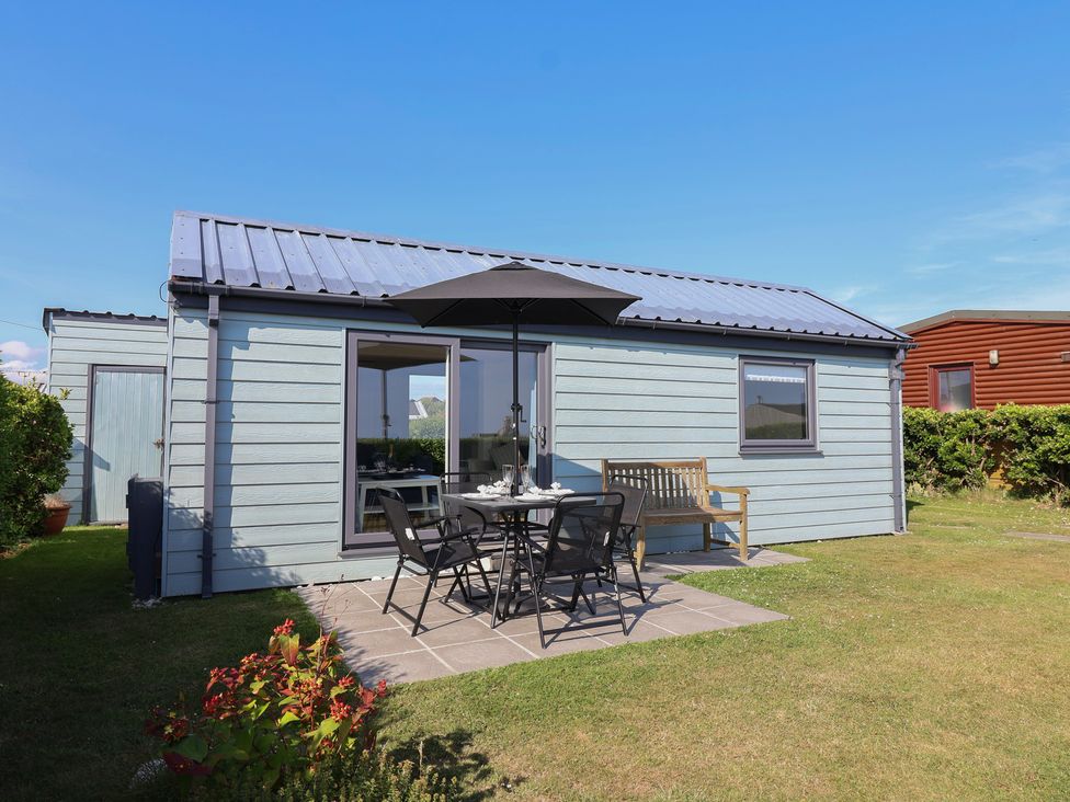 A cabin with a dining table and chairs outside at Stella Maris in Torpoint