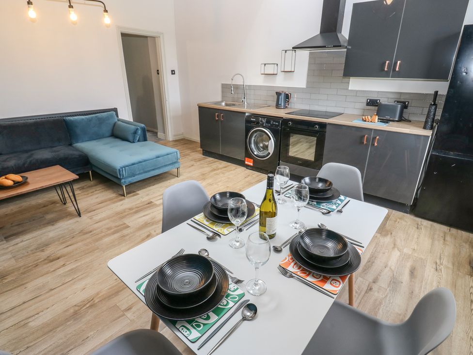 A dining area with a table set for a meal at Myrtle Loft in Keighley