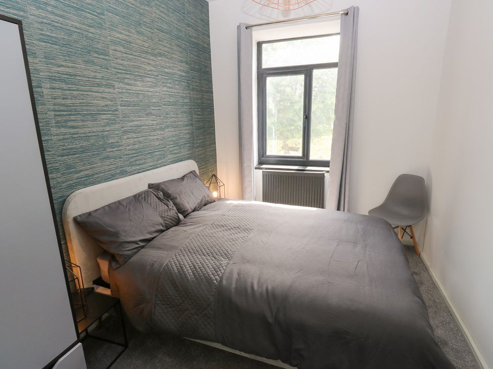 A bedroom with a bed and window at Myrtle Loft in Keighley