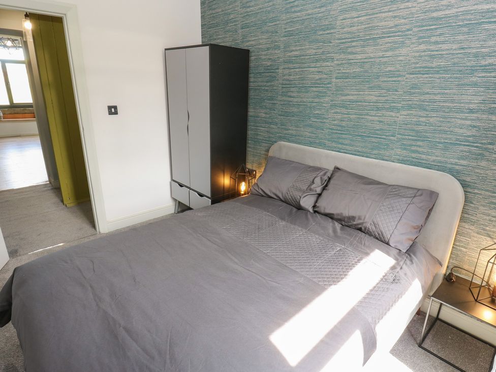 A bedroom with a bed and wardrobe at Myrtle Loft in Keighley