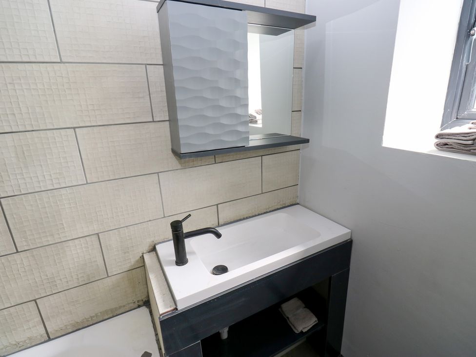A bathroom with a sink and mirror at Myrtle Loft in Keighley