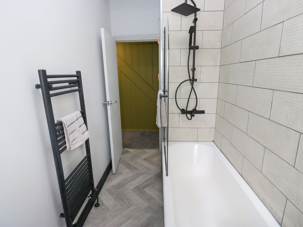 A bathroom featuring a bathtub and shower setup at Myrtle Loft in Keighley