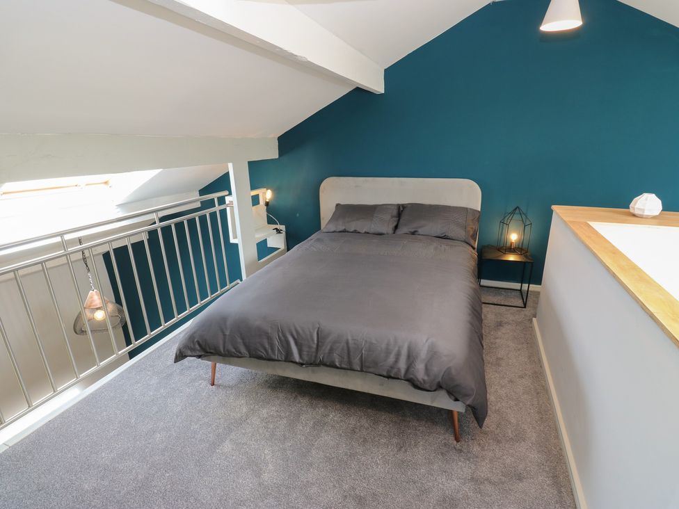 A bedroom featuring a bed with a bedside table at Myrtle Loft in Keighley