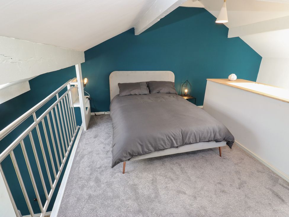 A bedroom with a bed and bedside table at Myrtle Loft in Keighley