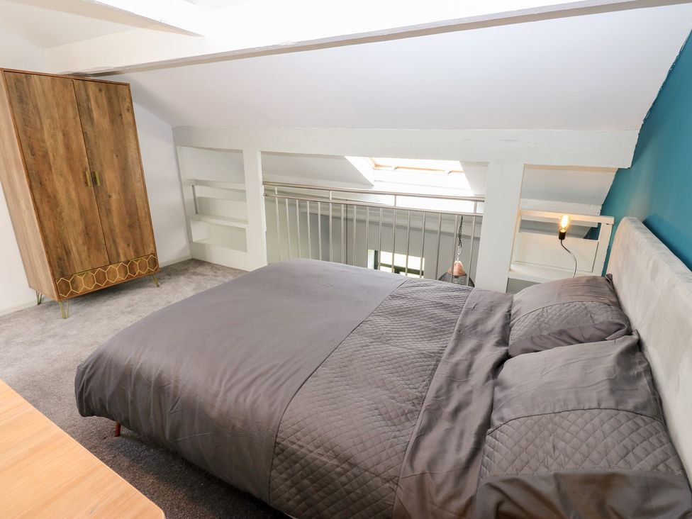 A bedroom with a bed and wardrobe at Myrtle Loft in Keighley