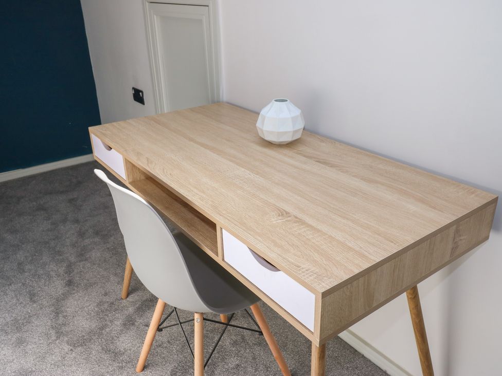 A desk with a lamp and chair in a home office at Myrtle Loft in Keighley