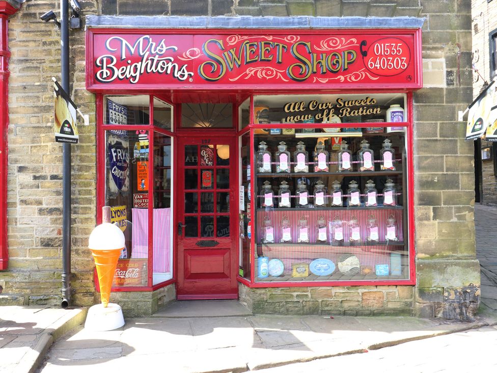 A sweet shop exterior with candy jars and an ice cream cone at Myrtle Loft in Keighley