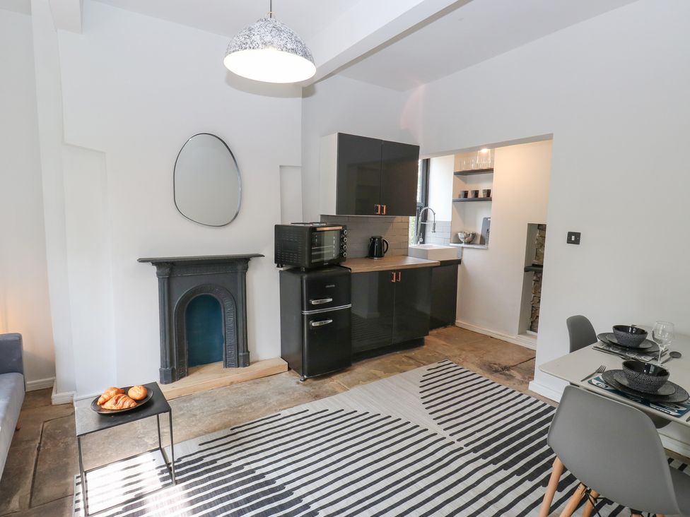 A kitchen with a dining table and a stove at Myrtle Nook in Keighley