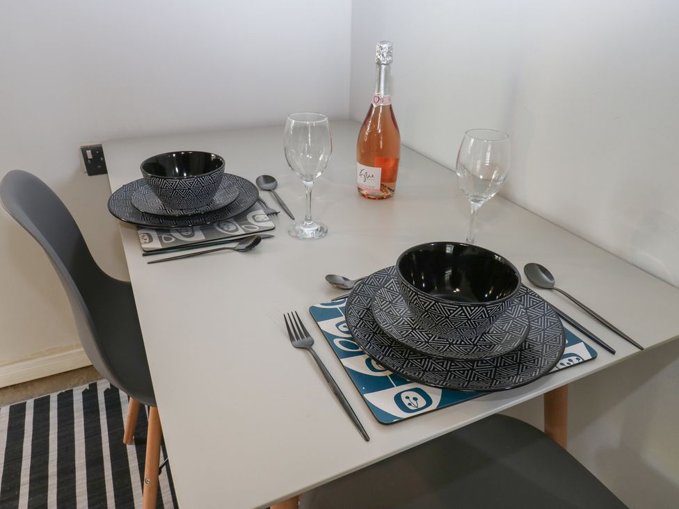 A dining table set with plates and wine at Myrtle Nook in Keighley