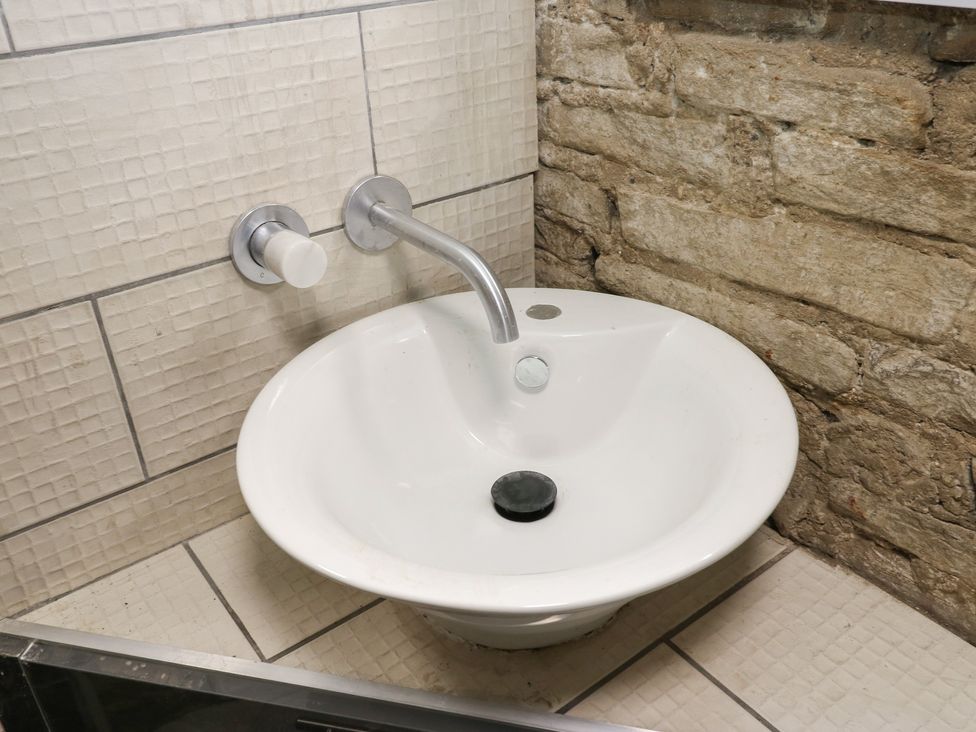 A sink with a faucet and wall tiles at Myrtle Nook in Keighley