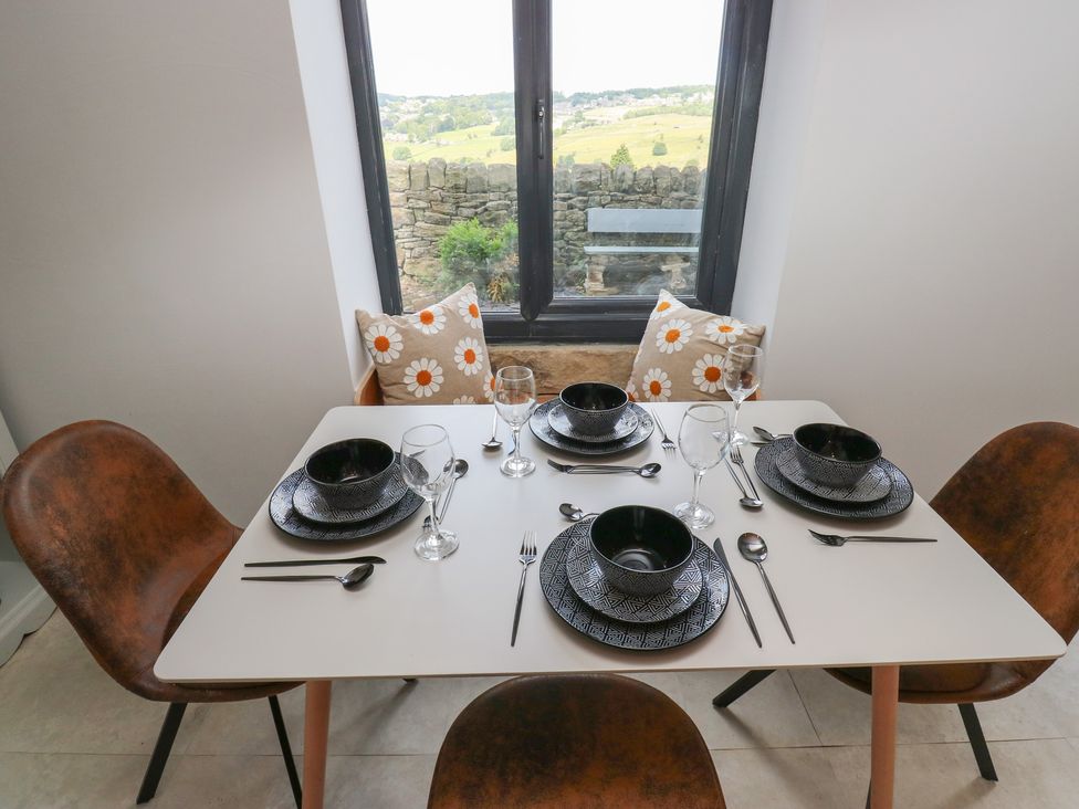 A dining table set with two bowls, glasses, and cutlery at Myrtle Vista in Keighley