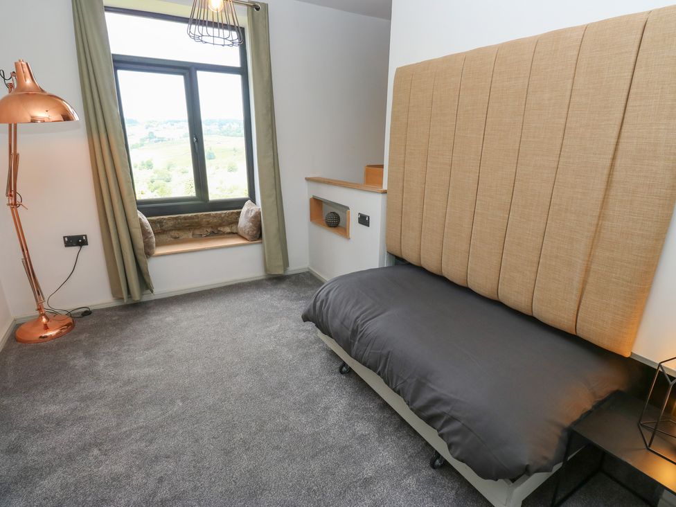 A bedroom with a bed and window seat at Myrtle Vista in Keighley