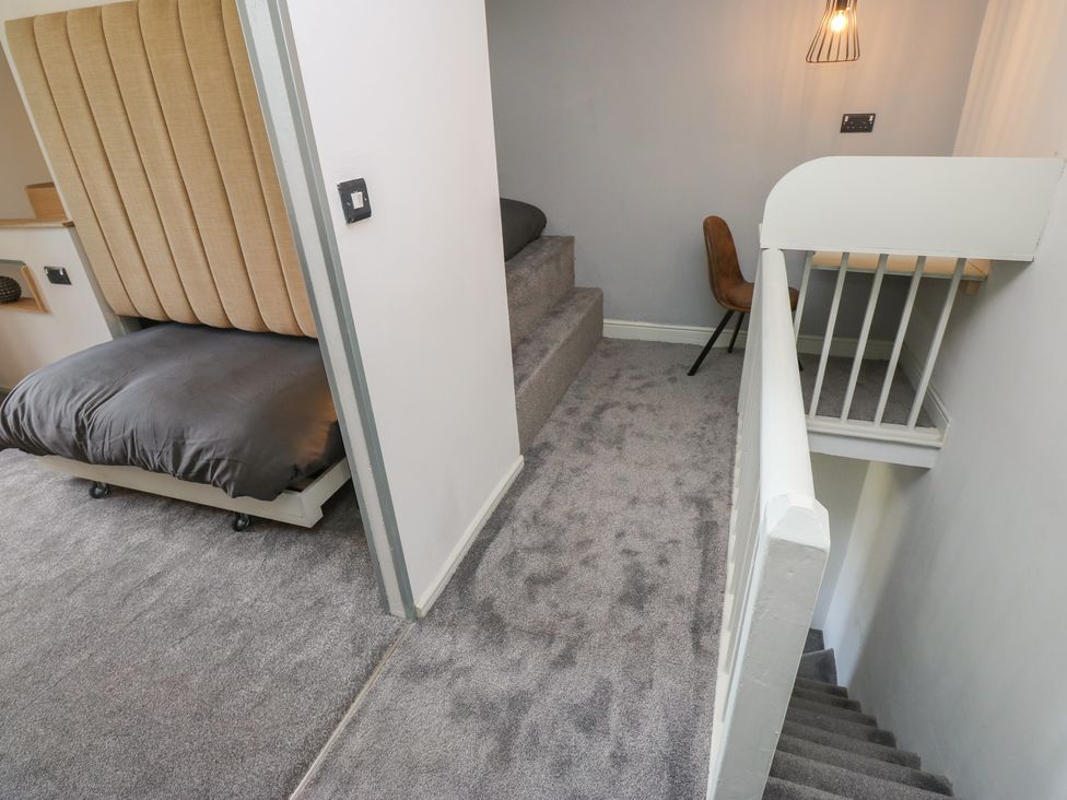 A bedroom with a bed and staircase at Myrtle Vista in Keighley