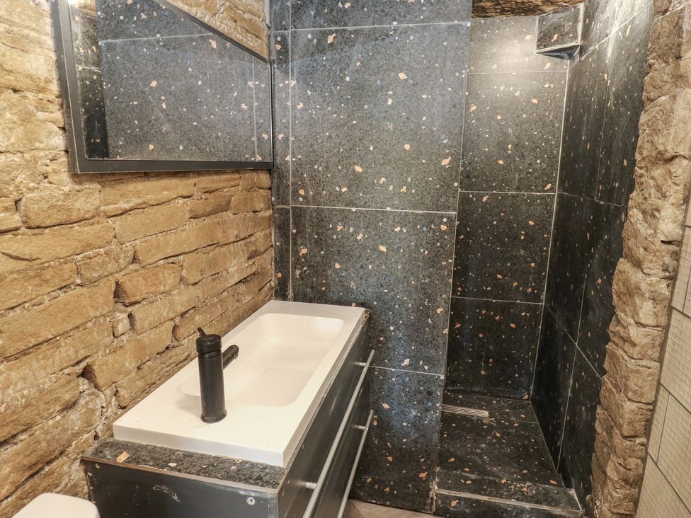 A bathroom with a sink and shower area at Myrtle Vista in Keighley
