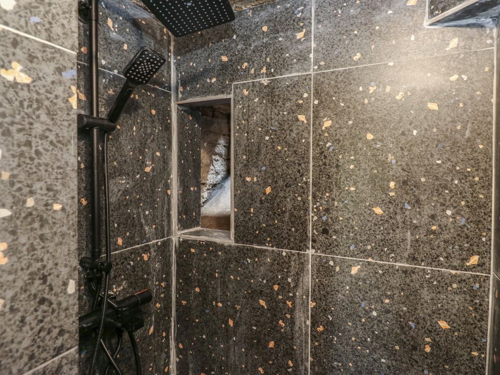 A shower area with granite tiles and a niche at Myrtle Vista in Keighley
