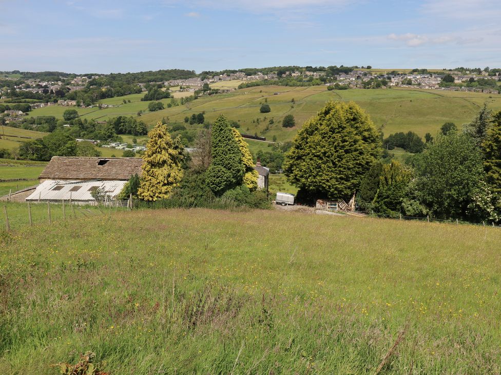 A barn surrounded by trees and a grassy field at Myrtle Vista in Keighley