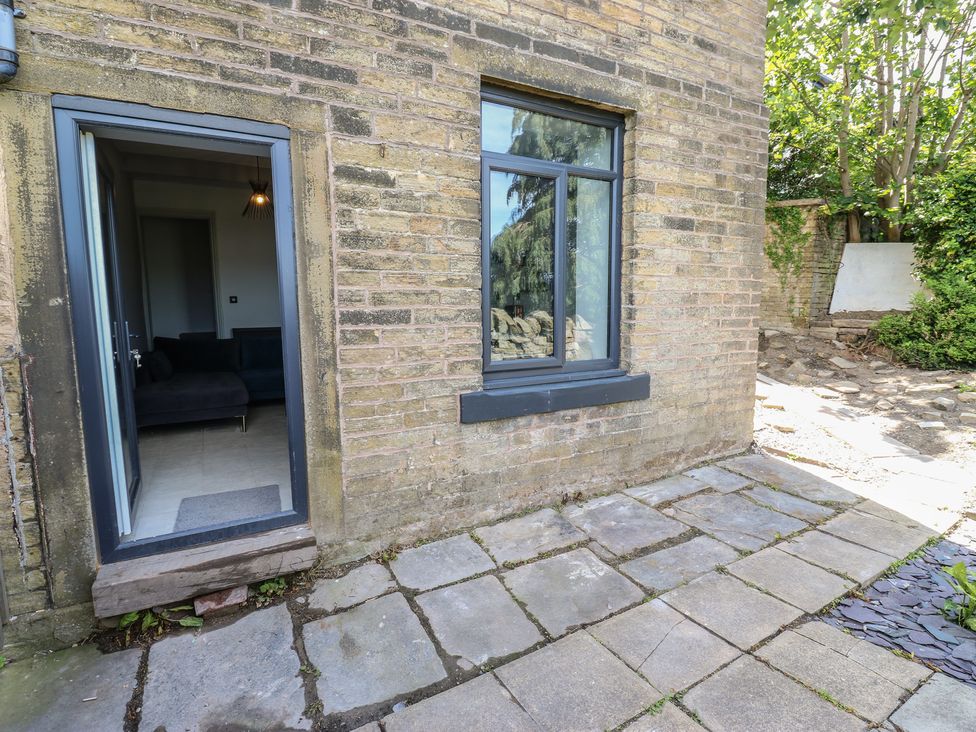 An outdoor patio area with a door and window at Myrtle Vista in Keighley