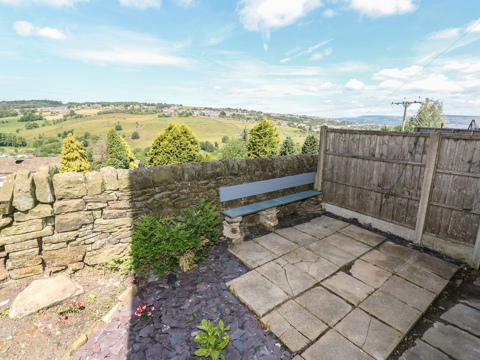 A garden area with a bench and stone wall at Myrtle Vista in Keighley