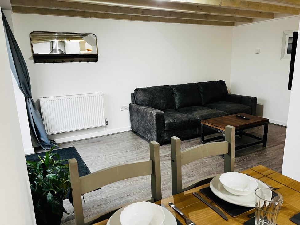 A living room with a sofa and coffee table at Barn Cottage in Frome