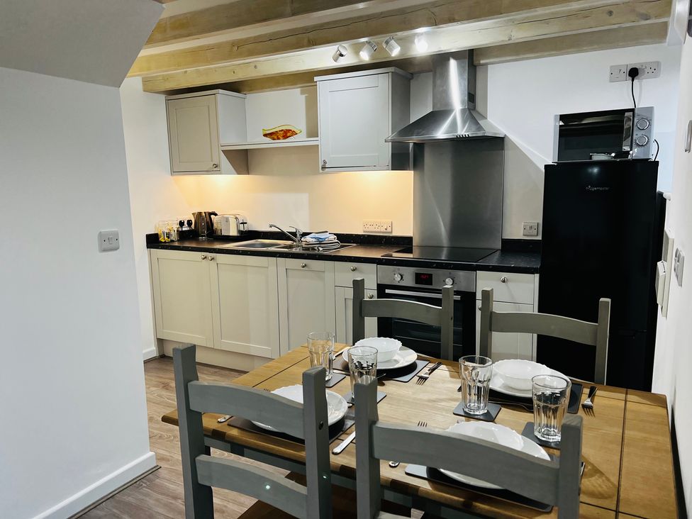 A kitchen with a table and chairs at Barn Cottage Frome