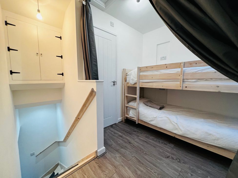 A bedroom with bunk beds and a storage cabinet at Barn Cottage in Frome