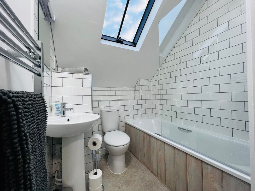 A bathroom with a bathtub, sink, and toilet at Barn Cottage in Frome