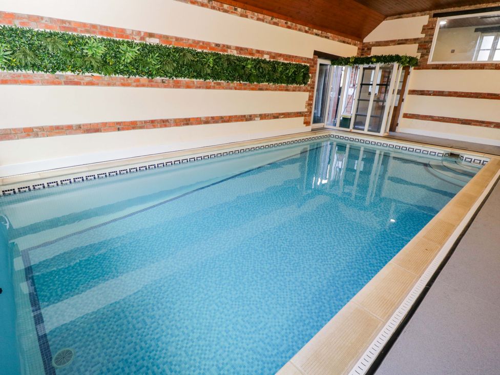 An indoor pool with tiled edges at Barn Cottage Frome