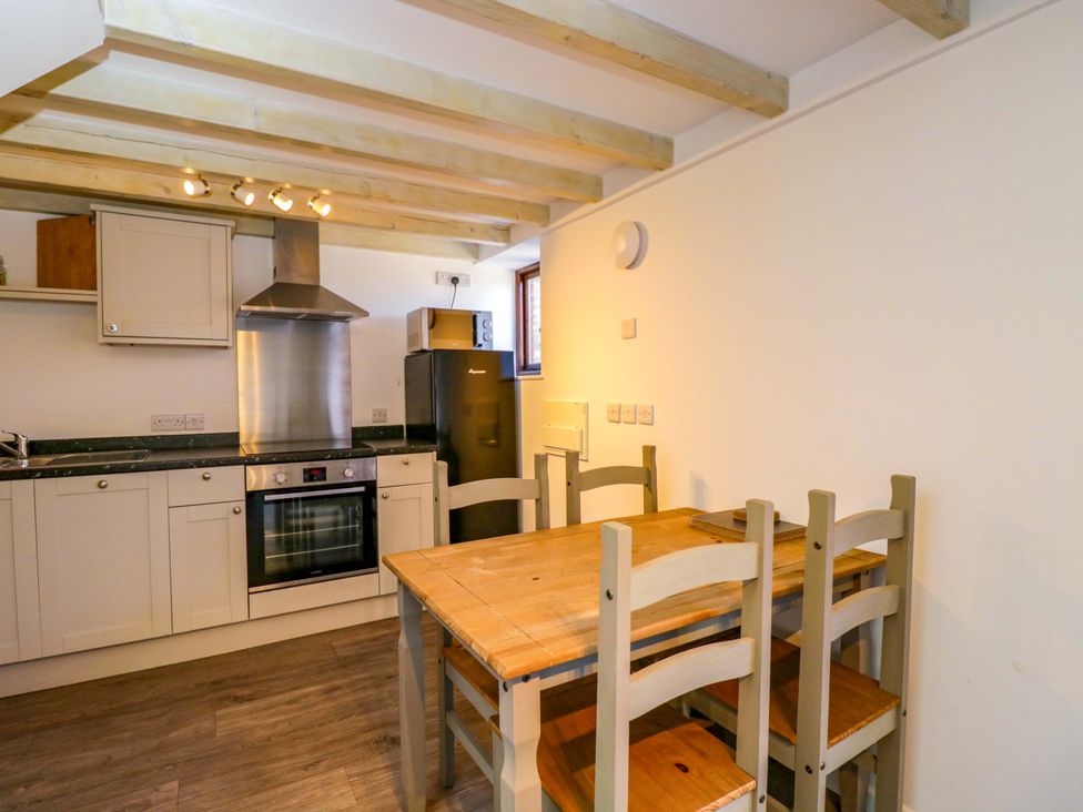A kitchen with a table and chairs at Barn Cottage in Frome