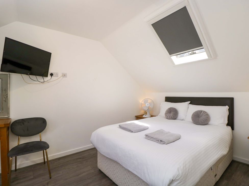 A bedroom with a bed and television at Barn Cottage in Frome