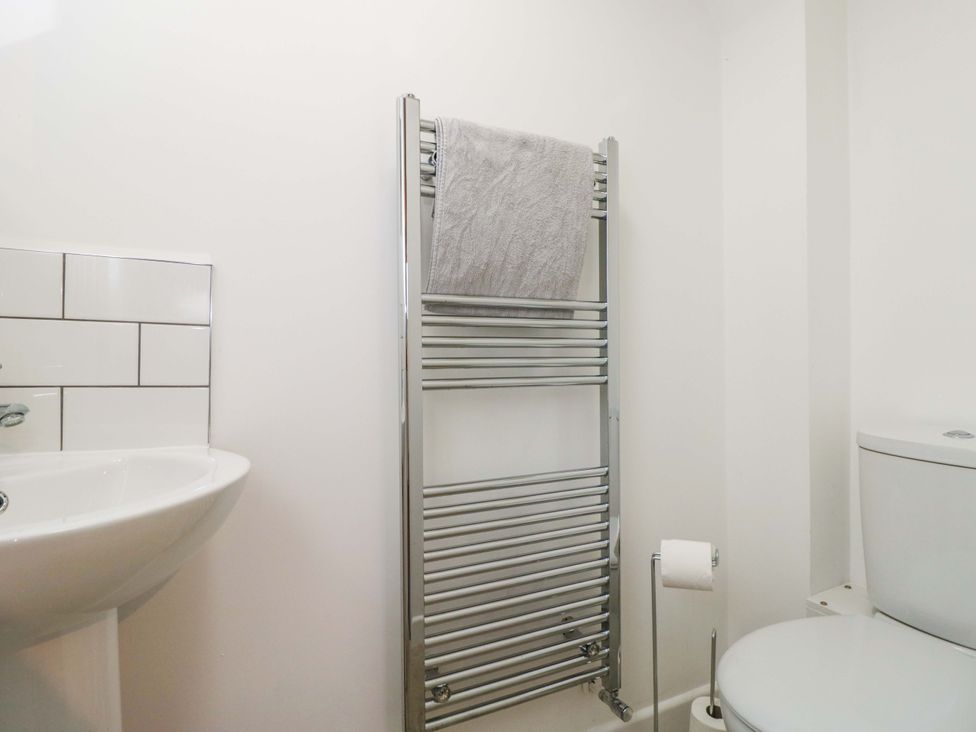 A bathroom with a sink, towel rail, toilet at Barn Cottage Frome