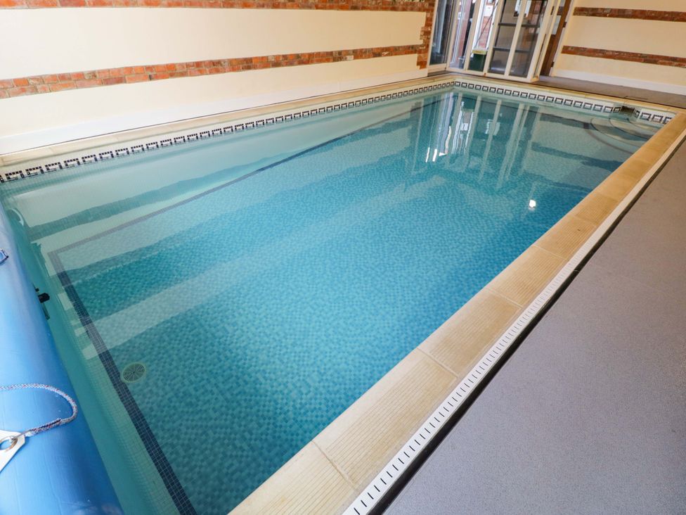 An indoor pool with tiled edges at Barn Cottage in Frome