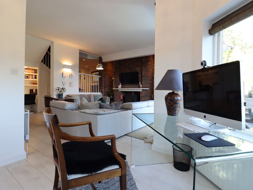A living room with a computer desk and sofa at Forest Getaway