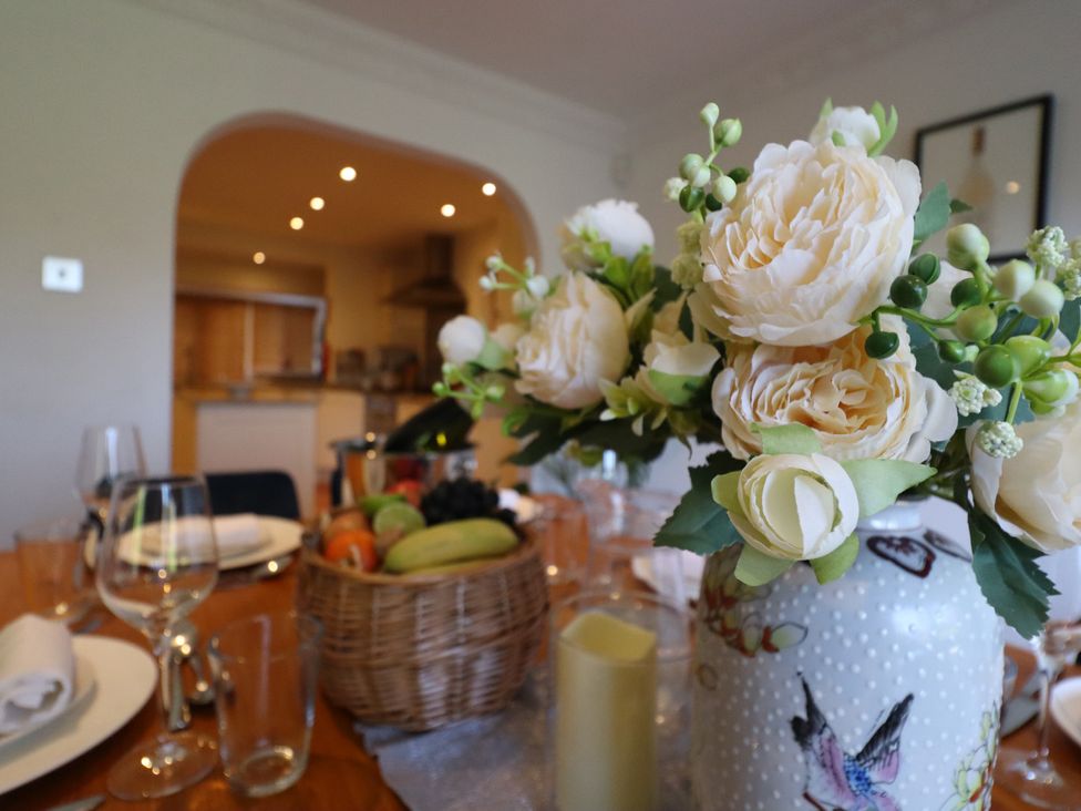 A dining table with flowers and fruit basket at Forest Getaway