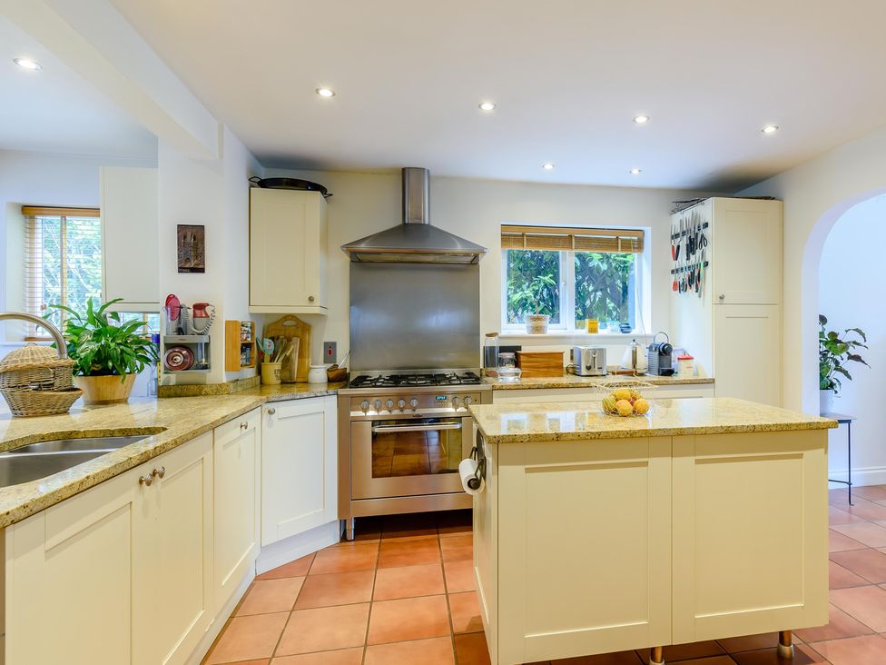 A kitchen with stove and kitchen island at Forest Getaway