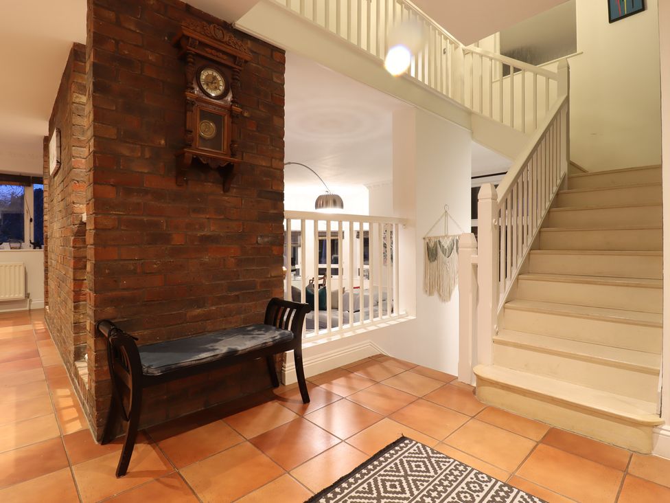 A hallway with a clock on a wall and a bench at Forest Getaway