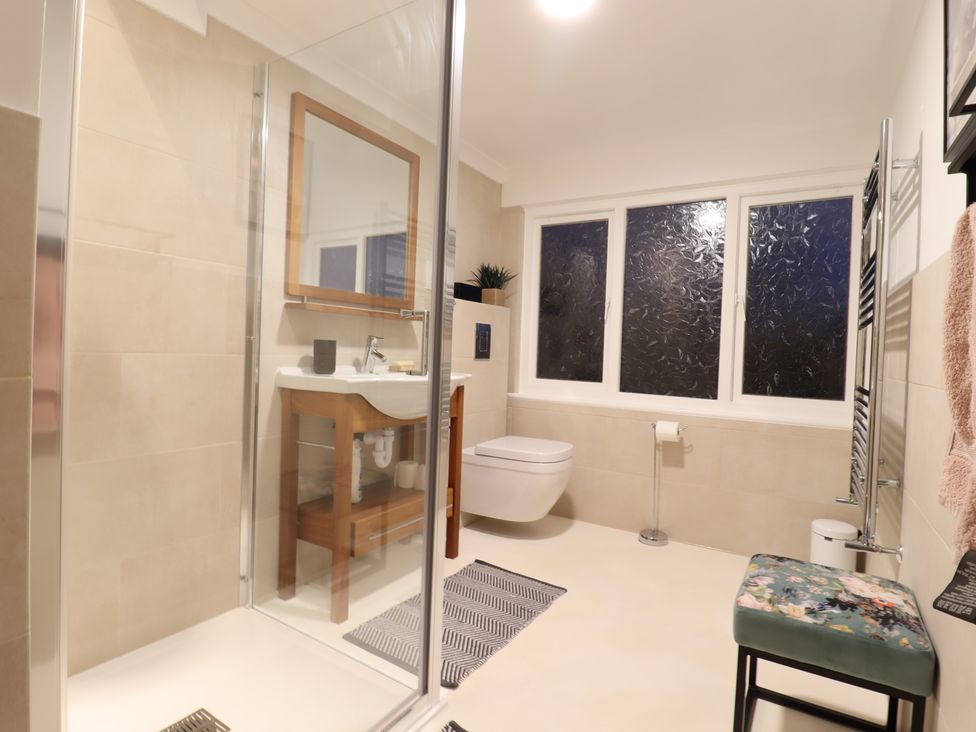 A bathroom with shower, sink, and toilet at Forest Getaway