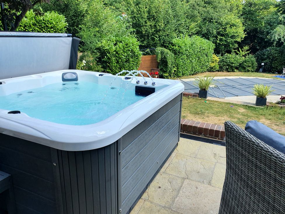 A hot tub in a garden with a patio at Forest Getaway