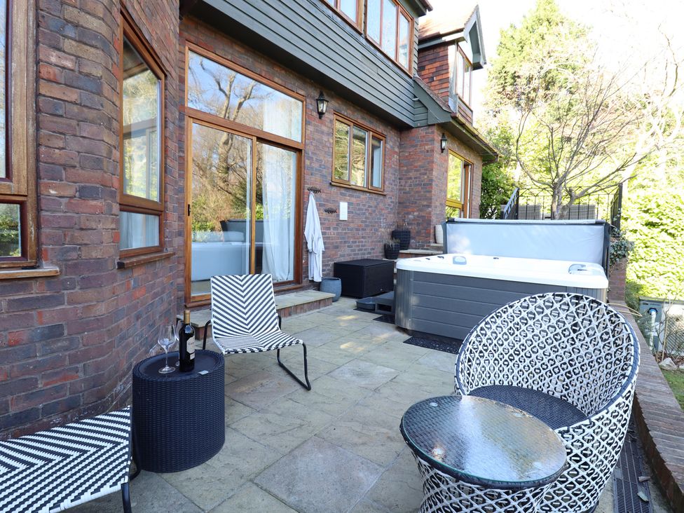 A patio with a hot tub and seating at Forest Getaway in 