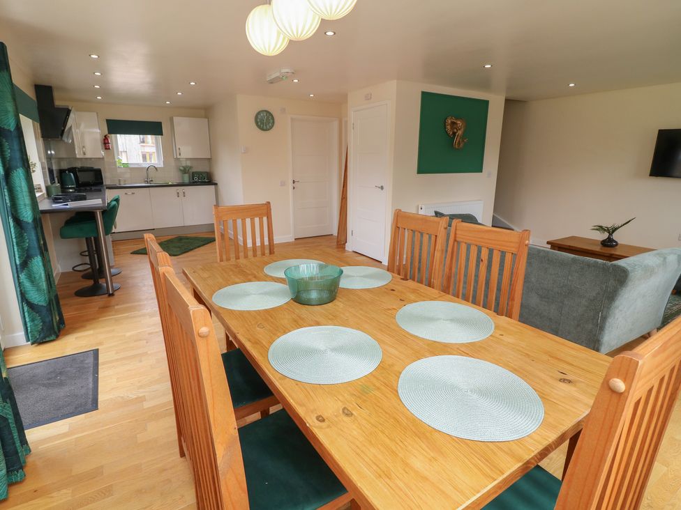 A dining area with wooden table and chairs at James Ville Marina Lodge 22 in Brigg
