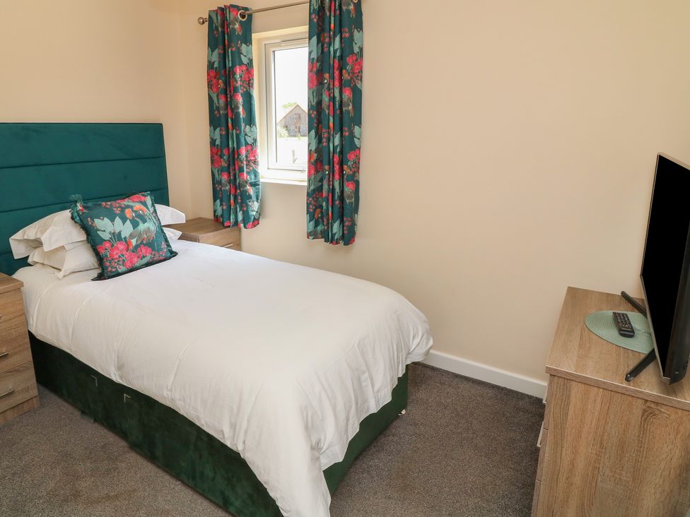A bedroom with a single bed and a television at James Ville Marina Lodge 22 in Brigg