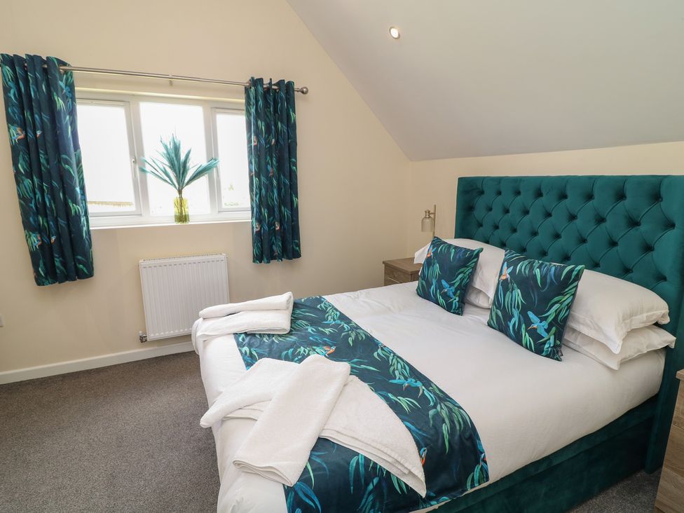 A bedroom with a bed and curtains at James Ville Marina Lodge 22 in Brigg