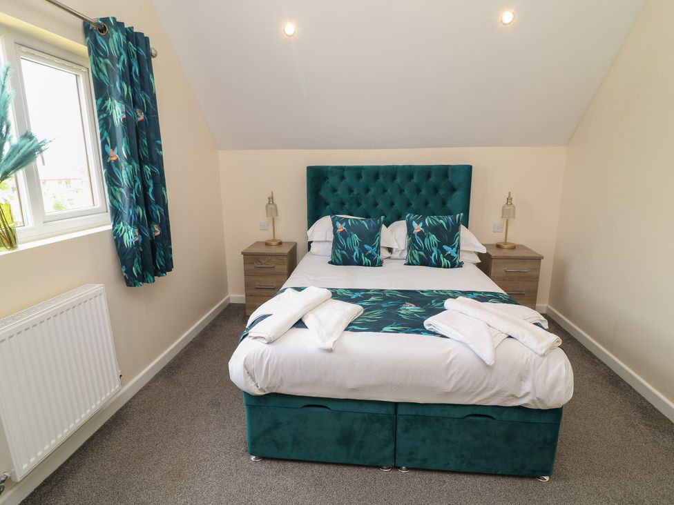 A bedroom with a bed and nightstands at James Ville Marina Lodge 22 in Brigg