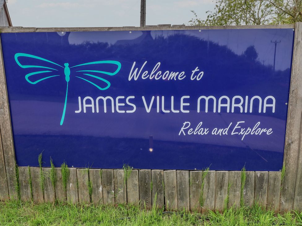 A sign for James Ville Marina with a dragonfly design in Brigg