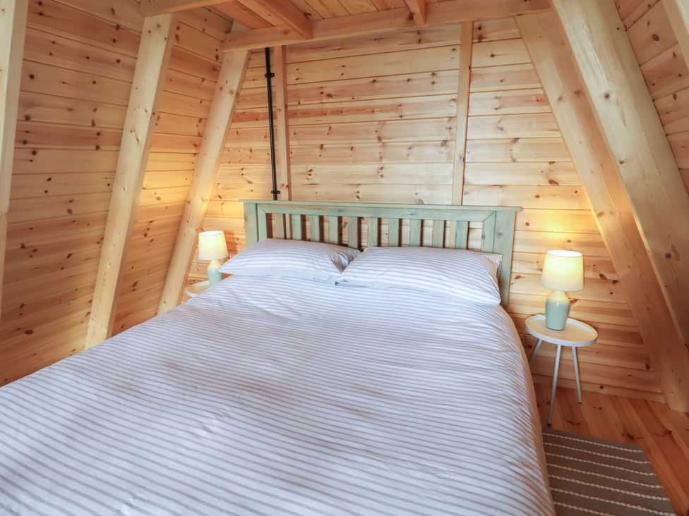 A bedroom featuring a bed, bedside table, and lamp at Robin in Monewden near Otley, Suffolk